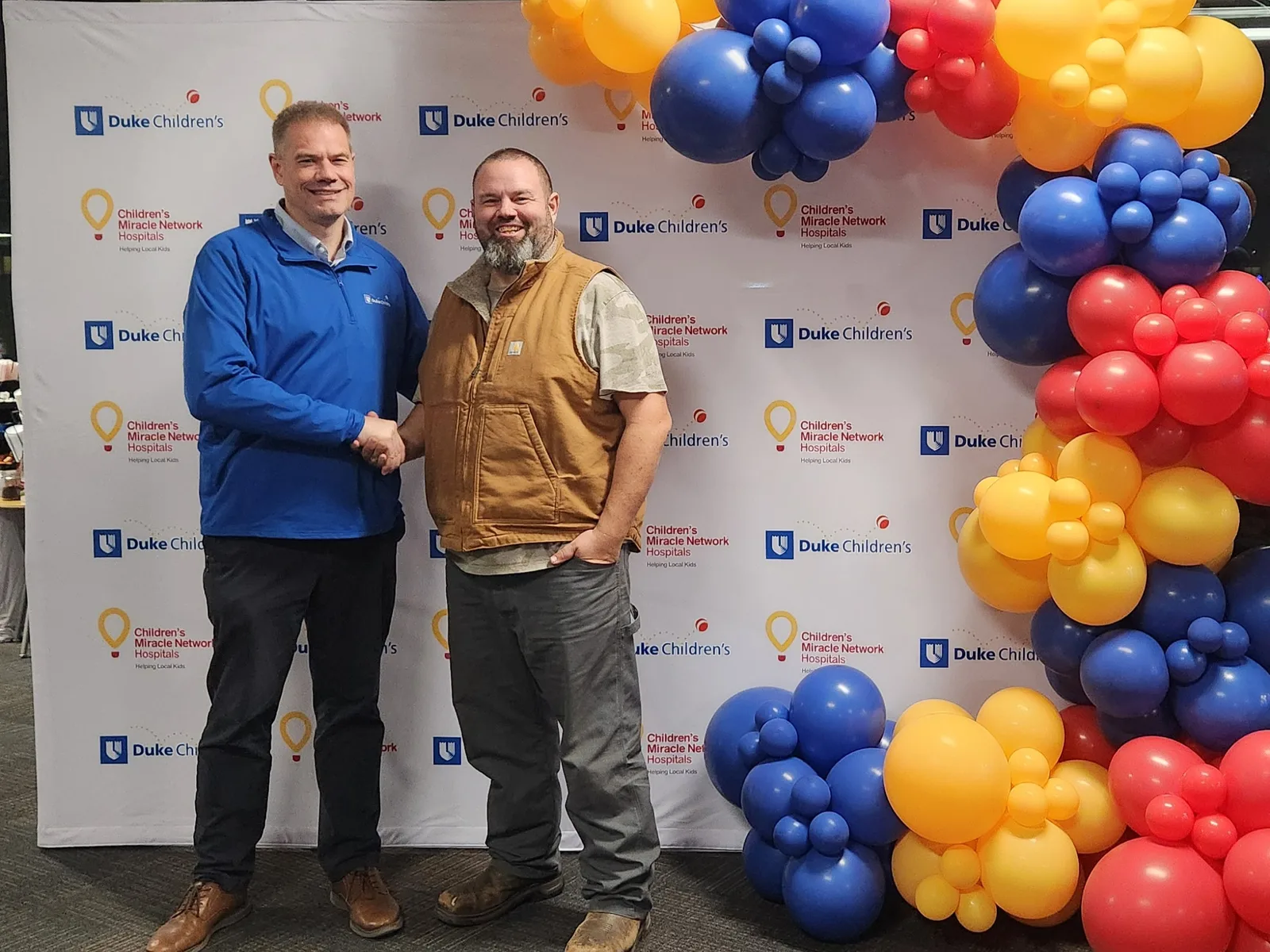 Jolly Raleigh owner with a Duke Children's Hospital representative